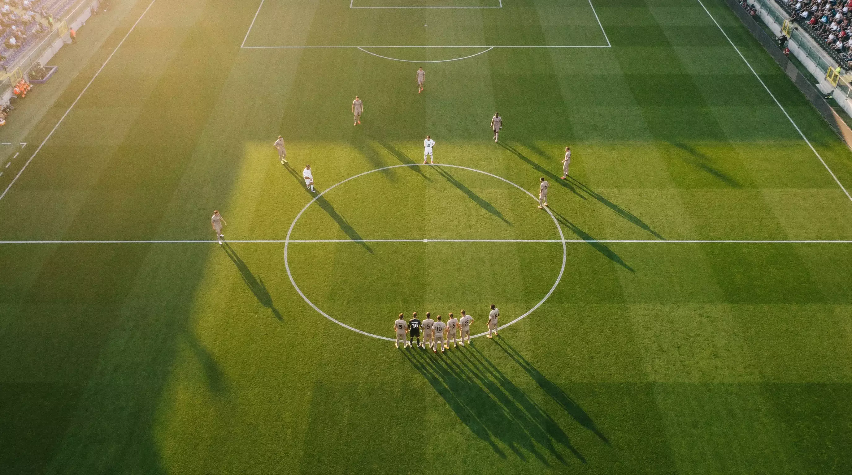 Campo da calcio visto dall'alto con le linee del terreno di gioco illuminate di sera