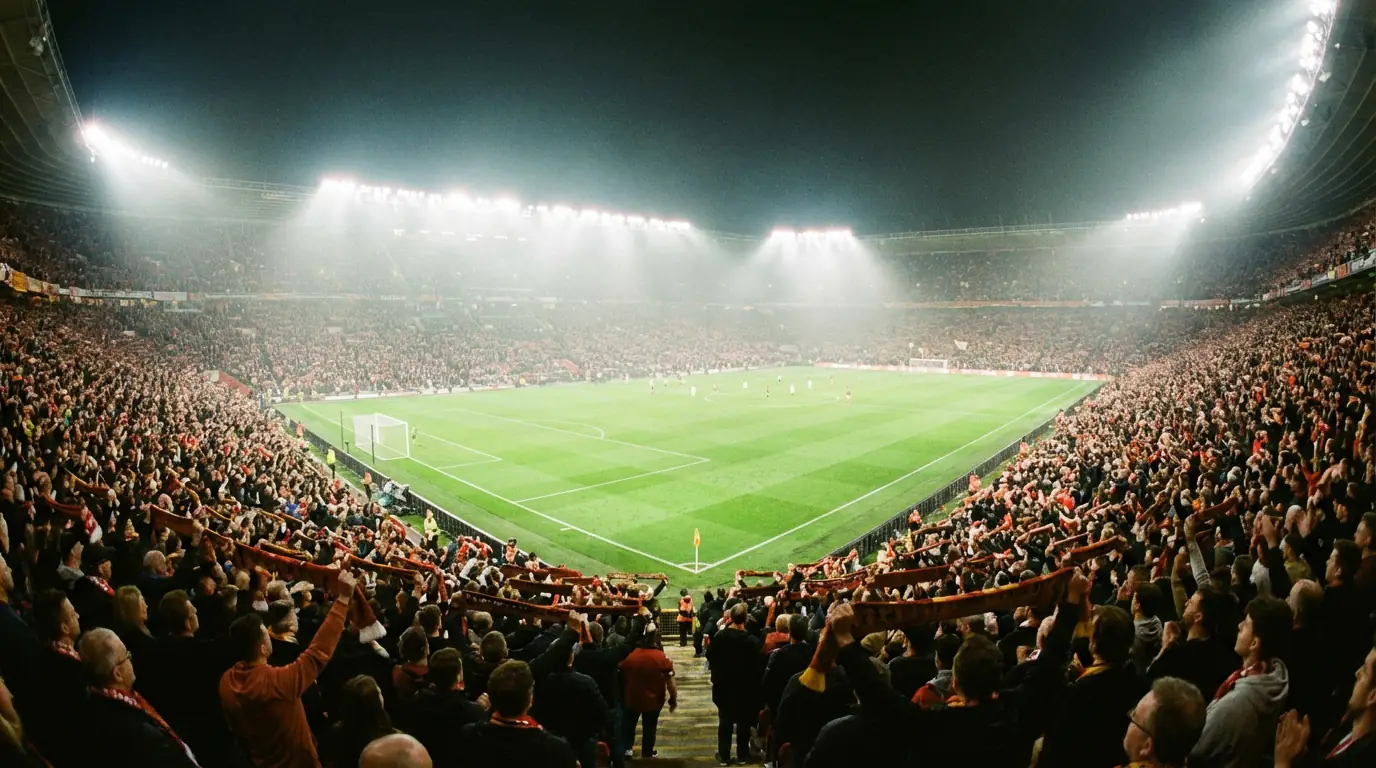 Veduta di uno stadio di calcio pieno di tifosi durante una partita serale sotto i riflettori