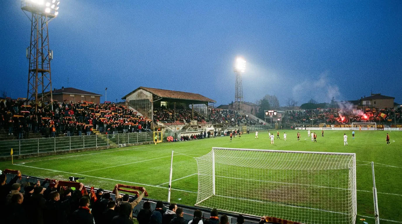 Stadio di Serie B italiano con tifosi sugli spalti durante una partita serale